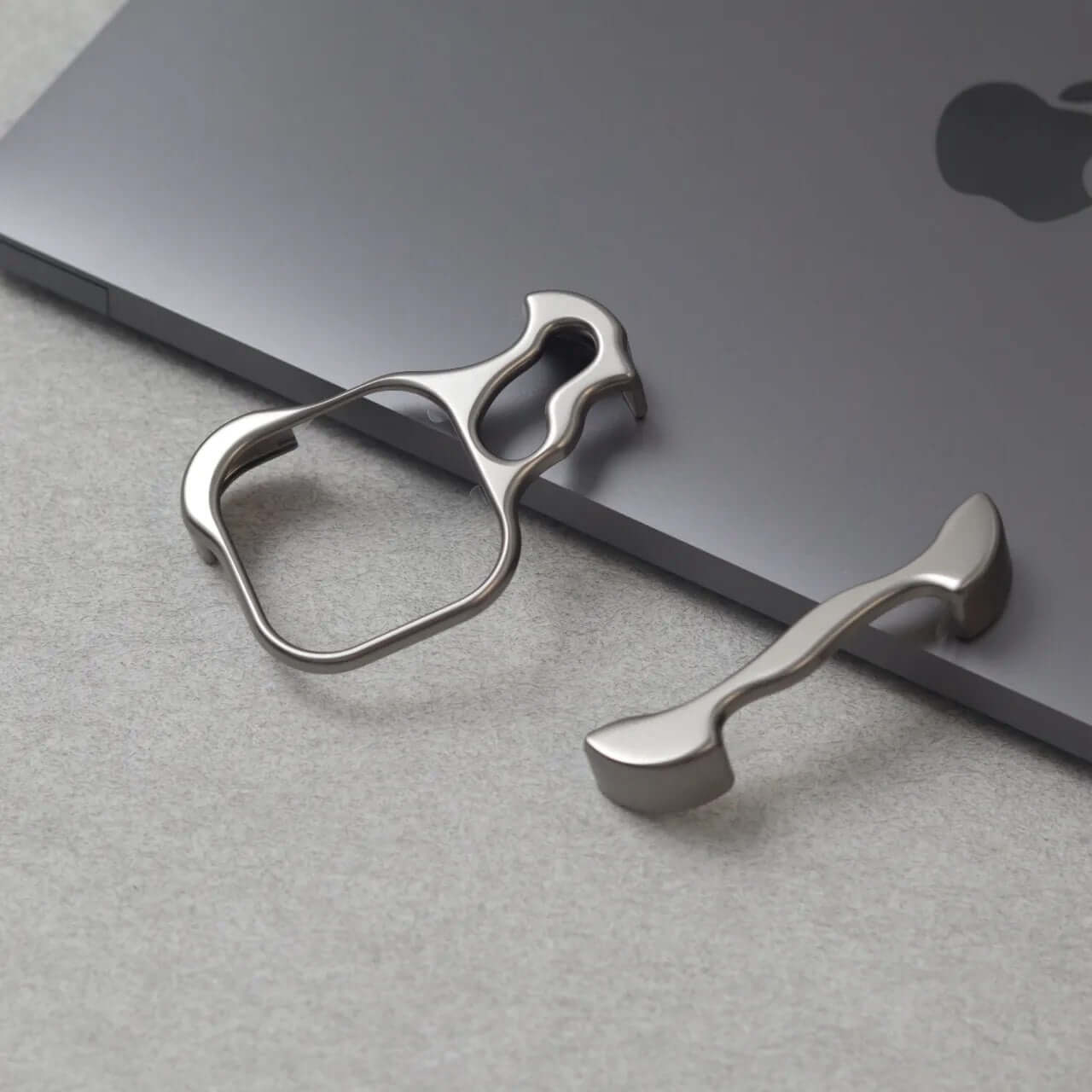 Zinc alloy phone cases accessories in minimalist design on a sleek grey surface featuring a MacBook.