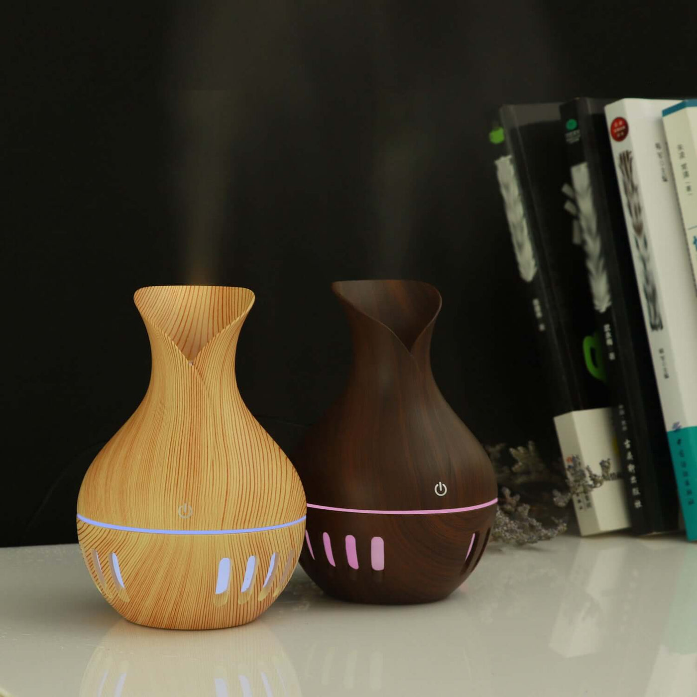 Hollow colorful mini USB humidifier in wood and dark brown finishes, emitting mist with LED lights in a modern setting.