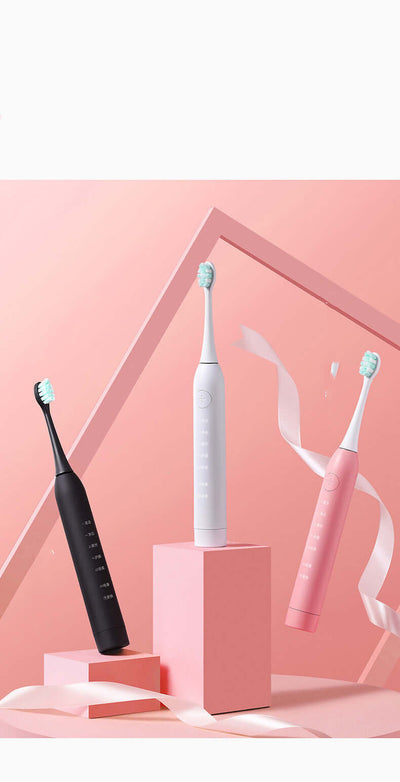 Three sonic electric toothbrushes in black, white, and pink on a pastel background, featuring modern design.
