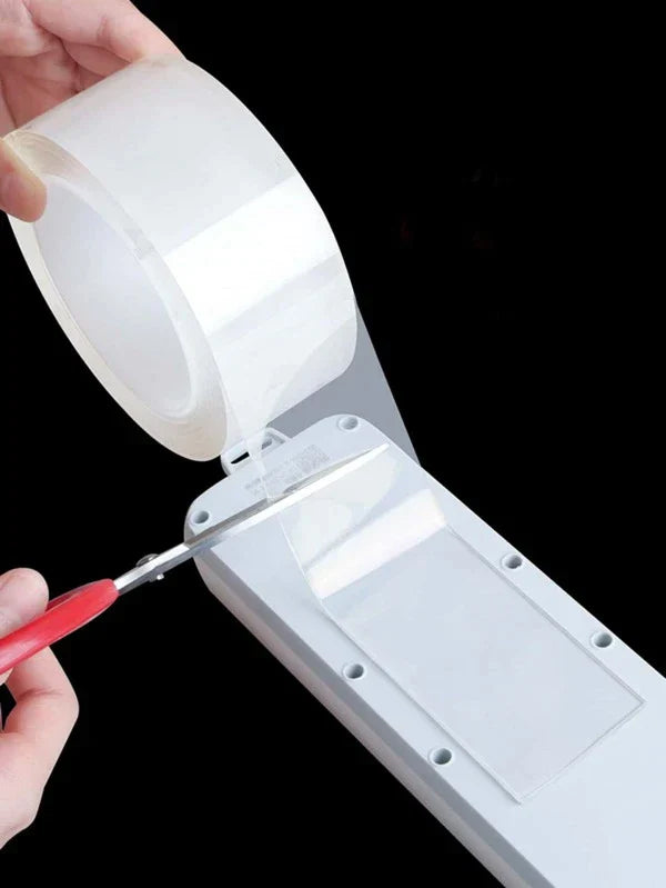 Hand cutting reusable double sided tape for versatile bonding on various surfaces.