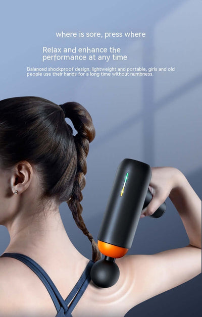 Woman using a mini massage gun on her shoulder for relaxation and muscle relief, showcasing its ergonomic design.