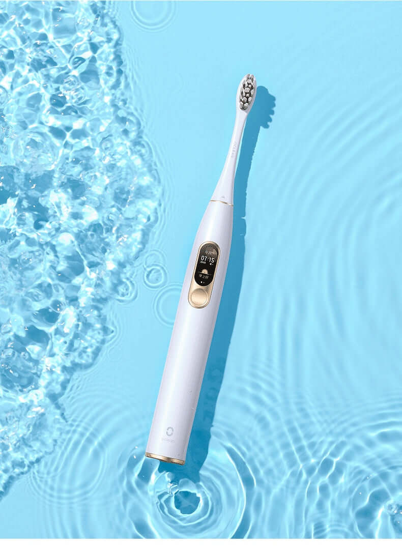 Electric toothbrush designed for maximum cleaning, featuring IPX7 waterproof body and USB charging base in a blue water setting.