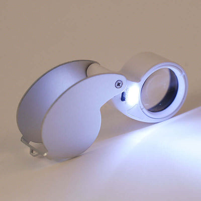Folding jewelry mirror with LED light in silver, compact, and lightweight design for easy portability and enhanced visibility.
