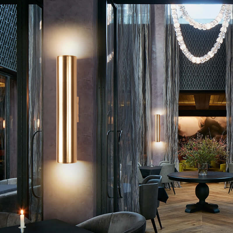 Iron vintage wall lamp illuminating a stylish dining area with modern decor and soft lighting.