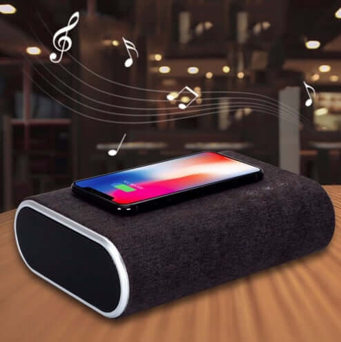 Wireless charger speaker with a smartphone, emitting music notes, perfect for home or office use.