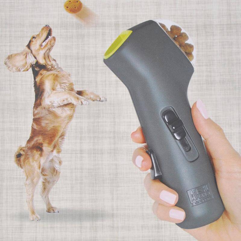 Person holding a Pet Treat Launcher, launching treats while a happy dog jumps to catch them.