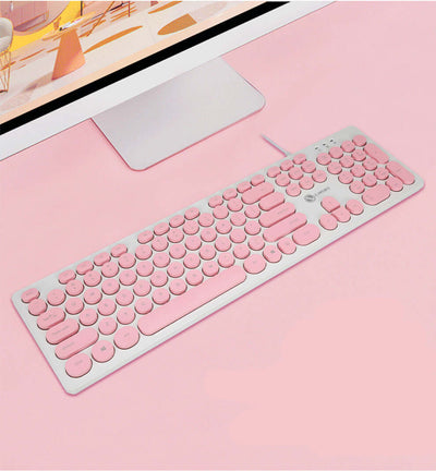 Pink mute keyboard with round keys on a light background, perfect for stylish home or office setups.