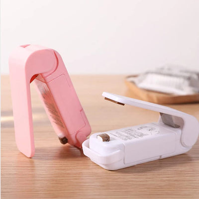 Mini heat sealer in pink and white, designed for sealing food bags airtight and keeping snacks fresh.