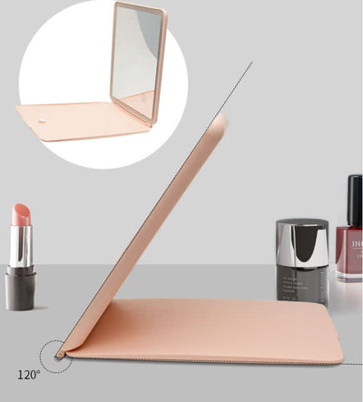 Clamshell desktop LED touch dressing mirror in pink, showcasing adjustable angles and stylish design with cosmetics.