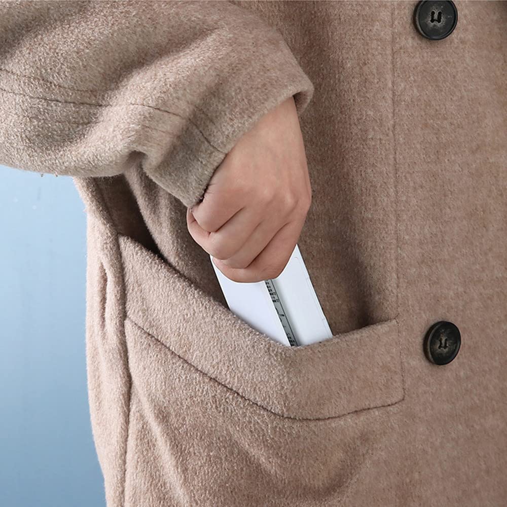 Person placing a portable device into the pocket of a cozy brown coat.