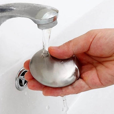 Person using odour removing steel soap under running water in the kitchen sink.