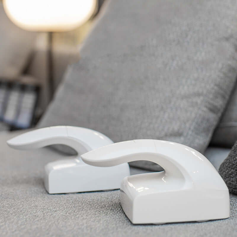 Two white pet hair removers on a gray sofa, designed for effective cleaning of cat hair and fur.