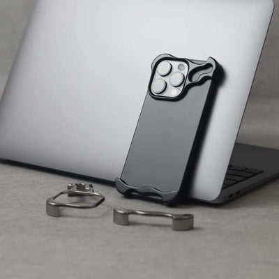 Zinc alloy minimalist phone case for iPhone 15 series, showcasing luxury design next to a laptop.