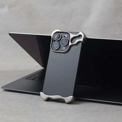 Zinc alloy phone case for iPhone 15 series in minimalist design, resting on a laptop for a sleek look.