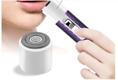 Woman using a portable electric razor for eyebrow trimming, featuring a detachable shaving head.
