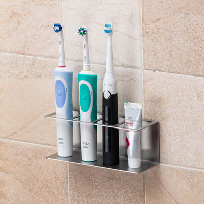 Stylish stainless steel electric toothbrush holder mounted on the wall, displaying three toothbrushes and toothpaste in an organized manner.