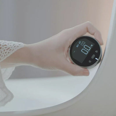 Person using a digital measurement tape to measure a surface with a clear display for accurate readings.