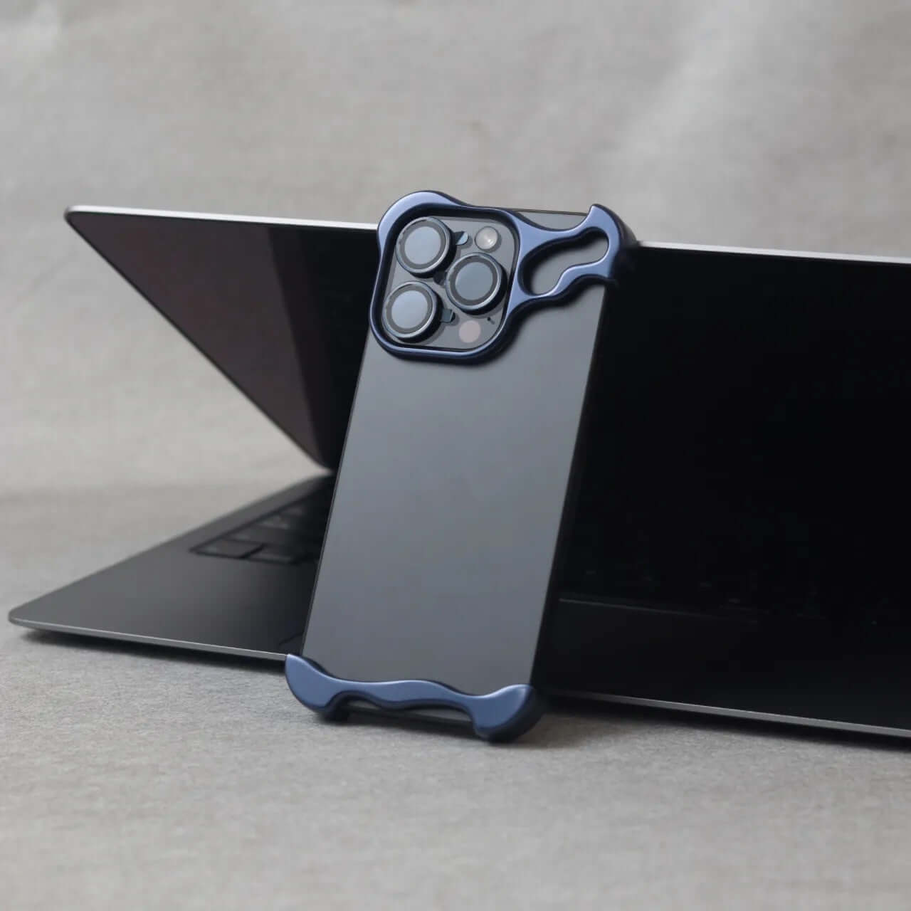 Zinc alloy protective case in Midnight Blue for iPhone 15, displayed on a laptop, showcasing minimalist style and luxury.