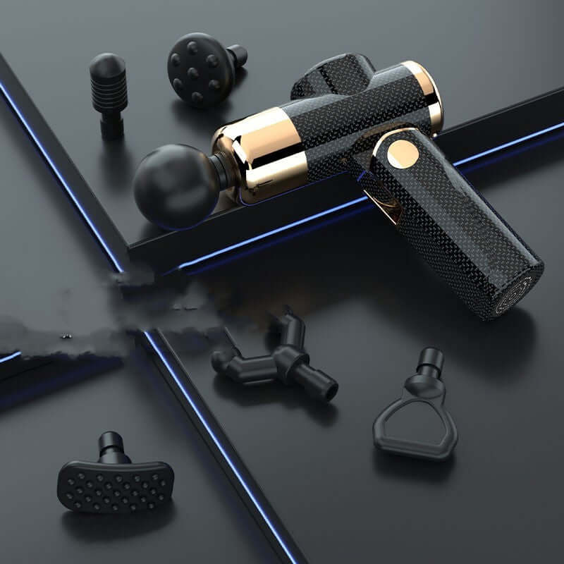 USB mini massage gun with multiple massage heads and sleek carbon fiber design on a modern surface.
