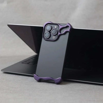 Zinc alloy protective phone case in dark purple on laptop, designed for iPhone 15 series with minimalist style.