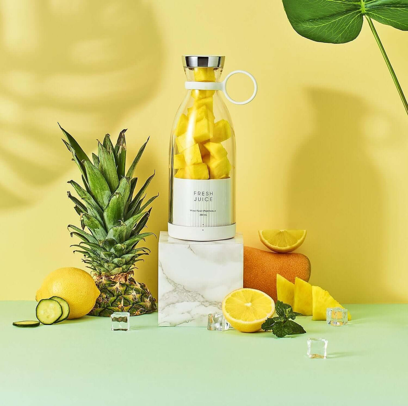 Blender Bottle with fresh fruit including pineapple, lemons, and mango, set against a vibrant background for healthy smoothies.