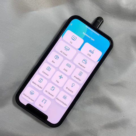 Smartphone displaying IR Phone Adapter controls for various devices like TV, air conditioner, and lights.