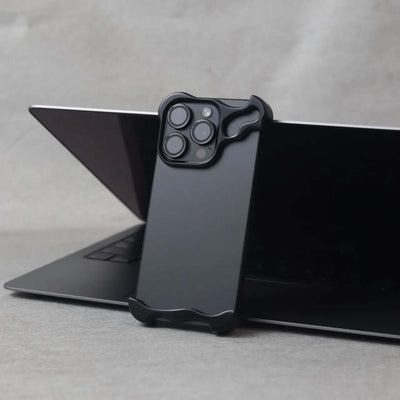 Zinc alloy protective case for iPhone 15 series in Gentlemen Black against a laptop background.