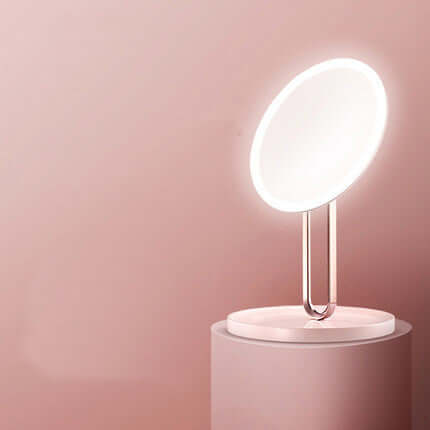 Desktop LED makeup mirror with light in cherry blossom pink, showcasing sleek design and modern functionality.