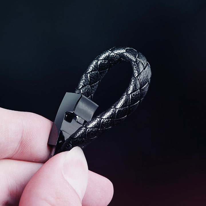 Black braided charging bracelet in hand, showcasing its sleek design and high-quality materials for on-the-go charging.
